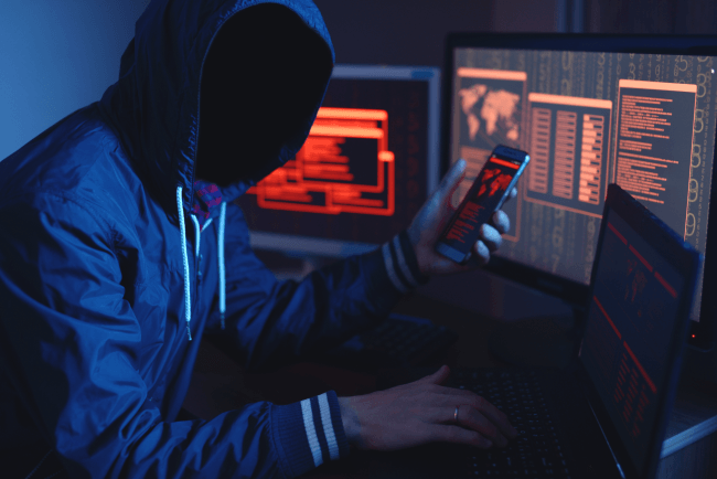 Un hacker anonimo senza volto che digita il codice cerca di rubare gli accessi